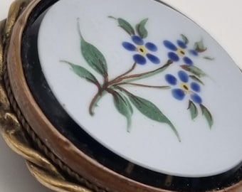 A substantial Victorian sentimental brooch, the 30mm hand painted enamel plaque set in a black border and framed by a solid gold rope twist.