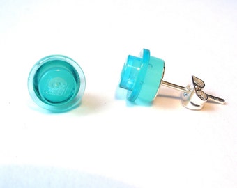 May include: A pair of turquoise blue Lego earrings. The Lego bricks are clear and have the Lego logo on them. The earrings are attached to silver posts.