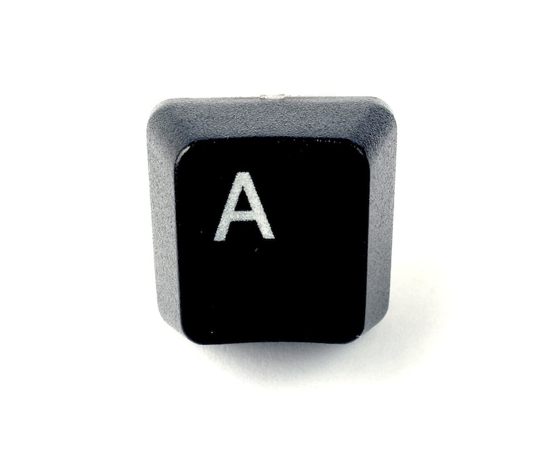 May include: Black computer keyboard key with the letter A printed in white.