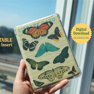 May include: Printable Kindle insert with a library card design featuring colorful butterflies. The insert has a clear plastic cover and is designed to fit a Kindle e-reader.