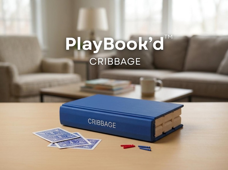 May include: A blue Cribbage game set in a book-like design. The game includes a blue book-shaped board, playing cards, and pegs. The text "PlayBook'd" and "CRIBBAGE" are visible on the game.