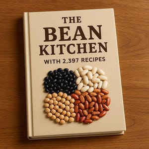 May include: A hardcover cookbook titled "The Bean Kitchen" with the text "WITH 2,397 RECIPES." The cover features four quadrants of beans: black, white, tan, and red. The book is on a wooden surface.