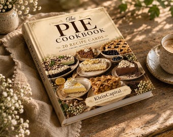 May include: A hardcover book titled The Pie Cookbook featuring 20 recipe cards. The cover displays various pie slices on small plates, including fruit, chocolate, and cream pies. The text KleinCapital appears on a decorative label at the bottom.