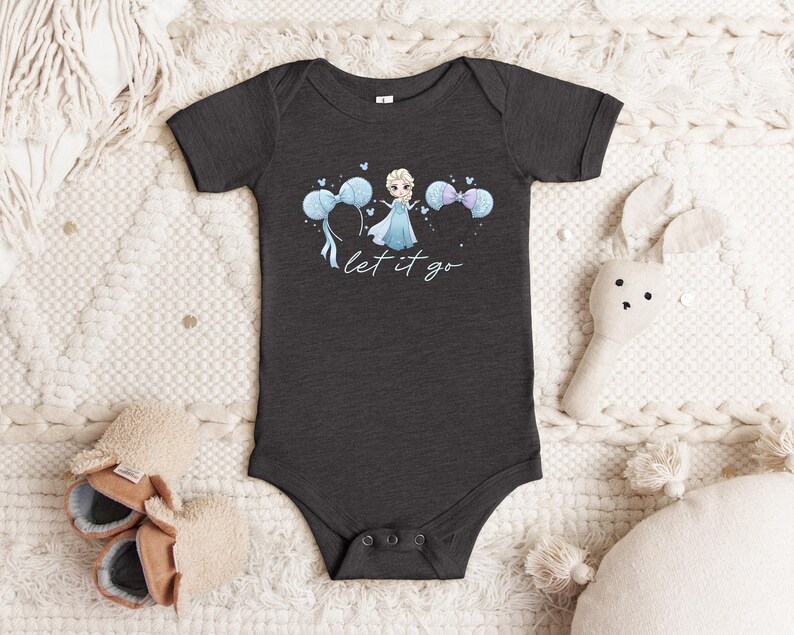 K&ouml;nnte beinhalten: Dunkelgrauer Baby-Body mit einer Cartoon-Prinzessin in blauem Kleid und blauen Luftballons. Der Text "let it go" steht in Schreibschrift darunter. Der Body hat kurze &Auml;rmel und Druckkn&ouml;pfe. Babybekleidung.