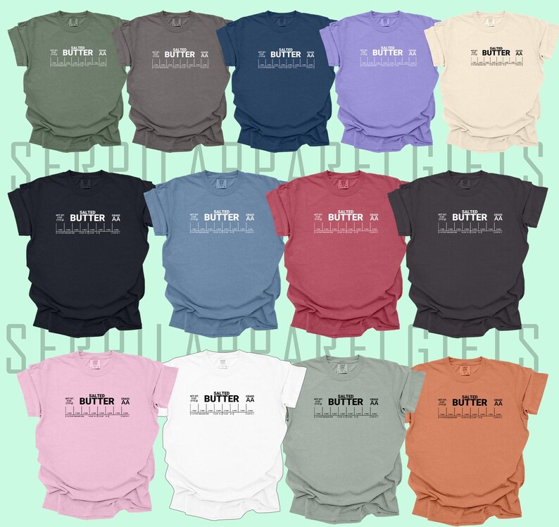 May include: A collection of ten t-shirts in various colours, each featuring a graphic of a stick figure holding a stick of butter with the text "Salted Butter" printed above it.