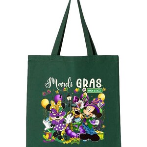 K&ouml;nnte beinhalten: Eine gr&uuml;ne Tragetasche mit schwarzen Henkeln. Die Tasche zeigt die Worte "Mardi Gras" in wei&szlig;er Schrift sowie Zeichentrickfiguren in festlicher Kleidung. Das Wort "FOREST" ist oben rechts aufgedruckt.
