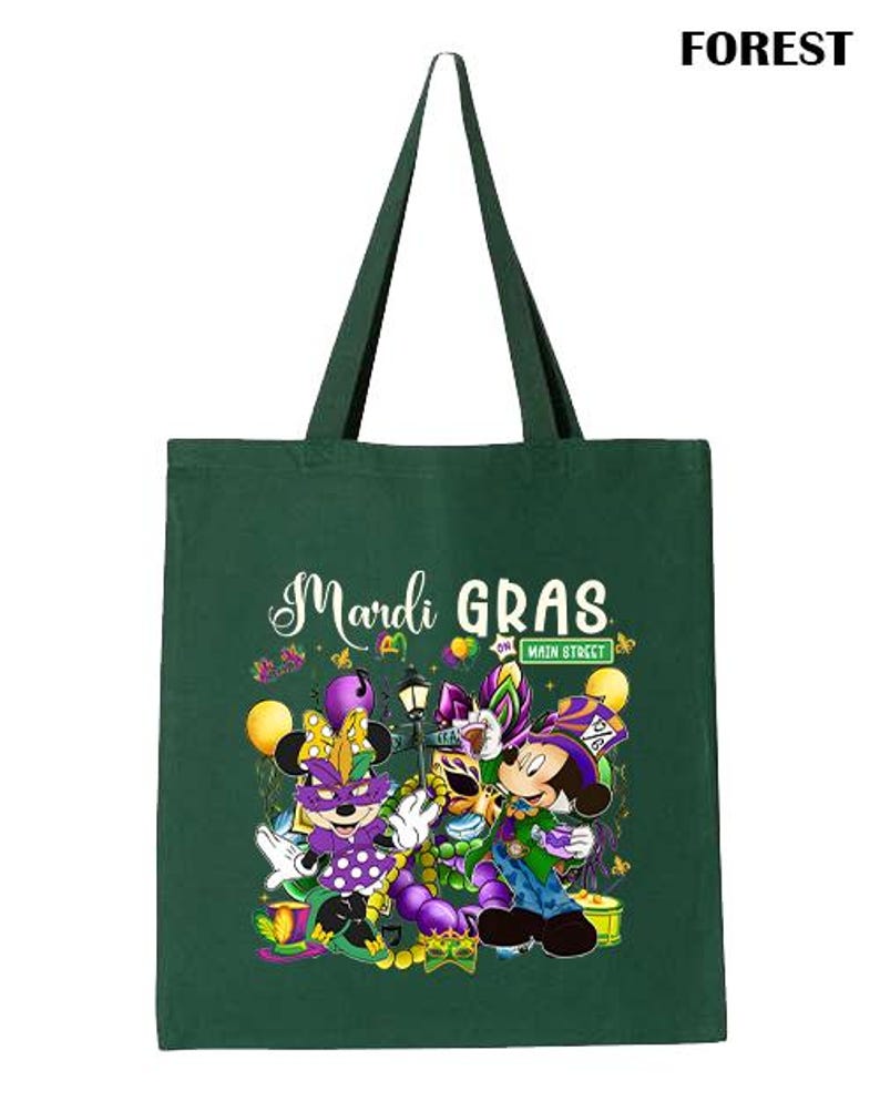 K&ouml;nnte beinhalten: Eine gr&uuml;ne Tragetasche mit schwarzen Henkeln. Die Tasche zeigt die Worte "Mardi Gras" in wei&szlig;er Schrift sowie Zeichentrickfiguren in festlicher Kleidung. Das Wort "FOREST" ist oben rechts aufgedruckt.