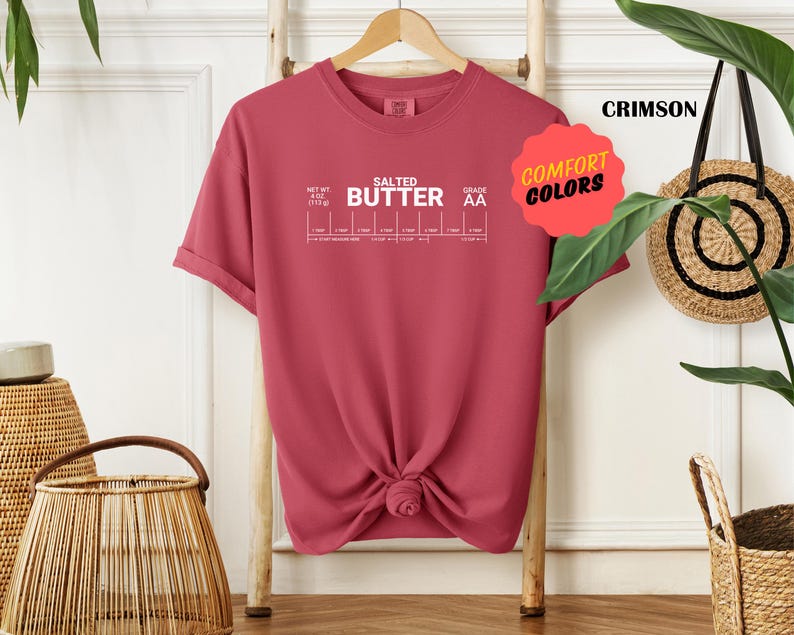 May include: A crimson t-shirt with the text "SALTED BUTTER" and a chart showing different grades of butter. The text "COMFORT COLORS" is in a yellow speech bubble.