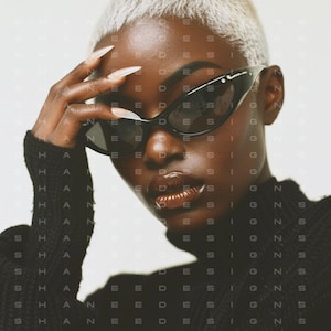 Puede incluir: Primer plano de una persona con gafas de sol negras de ojo de gato y un jersey de cuello alto negro. La persona tiene el pelo corto y rubio platino.