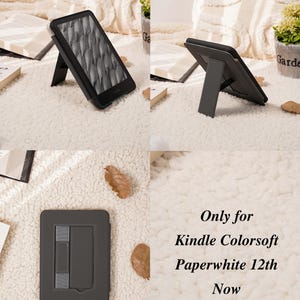 May include: A black protective case for a Kindle Colorsoft Paperwhite 12th Gen, featuring a built-in foldable stand on the back for upright viewing. The case has a smooth finish and includes a gray elastic hand strap. Text reads: Only for Kindle Colorsoft Paperwhite 12th Now.