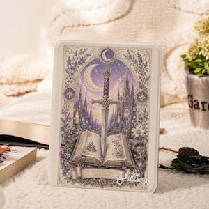 May include: A rectangular tablet case featuring a detailed illustration of a silver sword embedded in an open book. The scene includes a crescent moon, a gothic castle, and purple floral accents. The text "Brilleny" is printed in the bottom right corner.