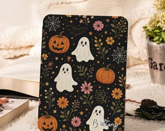May include: A rectangular tablet case featuring a black background with a repeating pattern of orange pumpkins, white ghosts, pink and orange flowers, spiderwebs, and small stars. The name Brittney is printed in white script in the bottom right corner.