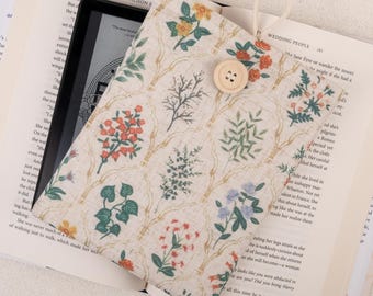 May include: A beige fabric e-reader case with a floral pattern featuring red, green, and blue flowers. The case has a button closure and a strap for carrying.