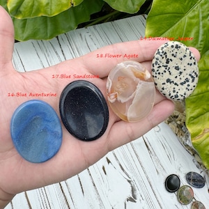 May include: Five smooth, polished palm stones in various colors and patterns. The stones are labeled with their names: Blue Aventurine, Blue Sandstone, Flower Agate, Dalmatian Jasper.