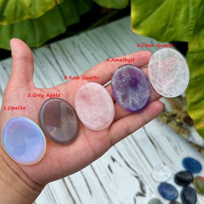 May include: Five oval-shaped polished stones, each with a different color and texture. The stones are labeled 1. Opalite, 2. Grey Agate, 3. Rose Quartz, 4. Amethyst, and 5. Clear Quartz.