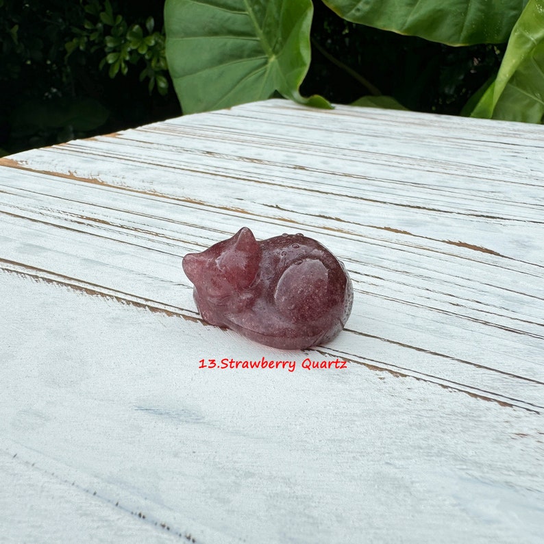 Pu&ograve; includere: Un gatto rosa e bianco addormentato scolpito in quarzo fragola. Il gatto &egrave; sdraiato sul fianco con la testa appoggiata sulle zampe. Il gatto &egrave; lungo circa 5 cm. 13.Quarzo fragola
