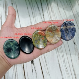 May include: Five polished oval-shaped stones, each with a different color and pattern. The stones are labeled with their names: Kambaba Jasper, Black Obsidian, Unakite, Crazy Agate, and Sodalite.