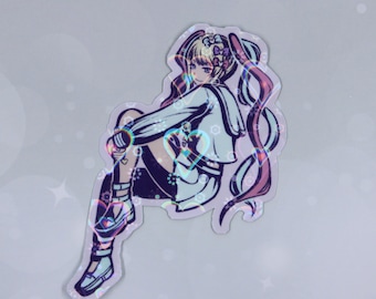 Puede incluir: Pegatina holográfica con un personaje de estilo anime sentado, con cabello rubio y largos acentos rosas y morados. El personaje viste un atuendo blanco y azul con un detalle en forma de corazón. Acabado iridiscente reflectante.