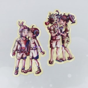 May include: Two sticker sheets featuring cartoon illustrations of couples. One sticker shows two figures kissing, while the other shows two figures holding hands and embracing. The figures are wearing shorts and tops, with a light yellow border.