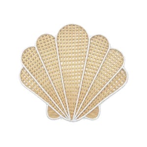 Puede incluir: Un salvamanteles decorativo con forma de concha. El salvamanteles está hecho de ratán tejido de color natural con un borde blanco. El diseño presenta un patrón en forma de abanico, que evoca un tema costero o de playa.