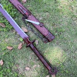 Peut inclure: Une &eacute;p&eacute;e rouge fonc&eacute; avec un fourreau assorti pr&eacute;sentant des motifs en relief complexes rappelant des dragons. L'&eacute;p&eacute;e poss&egrave;de une lame incurv&eacute;e, un manche textur&eacute; et un pommeau en forme de dragon. Une cha&icirc;ne m&eacute;tallique relie le fourreau &agrave; un petit poignard tranchant.
