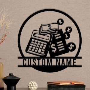 Op de afbeelding: Zwarte metalen wandkunst met een rekenmachine, geld en valuta symbolen. De tekst "CUSTOM NAME" wordt onderaan het ontwerp weergegeven.
