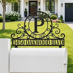 May include: A black metal mailbox topper featuring a circular monogram with the letter P, the name PATERSON, and the text EST. 2023. Below the circle, a rectangular panel displays the address 3450 OAKWOOD BLVD in a bold, sans-serif font.
