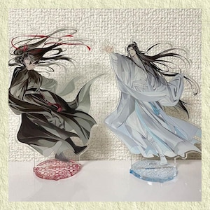 May include: Two acrylic anime character figures. One figure is in black and gray robes with red accents, the other in white and light blue robes. Both figures have long black hair and are on decorative bases.