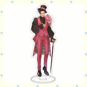 May include: A decorative acrylic figure of a character in a pink suit, black shirt, and top hat, holding a cane and a pink flower. The figure is standing on a clear base, with a detailed illustration of the character's outfit.