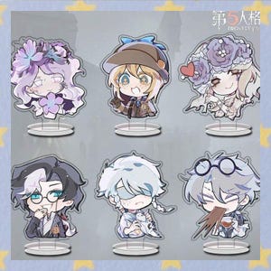 Puede incluir: Seis figuras acrílicas de personajes con ilustraciones de estilo anime. Los personajes tienen ojos grandes y están representados con varios atuendos y poses. Cada figura está montada sobre una base transparente. El fondo es azul claro con estrellas y texto japonés.