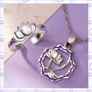 Peut inclure: Un ensemble bague et collier argentés avec un motif de fleur de lotus. La bague est réglable et le collier a un pendentif avec une fleur de lotus à l'intérieur d'un cadre géométrique bordé de violet. Les bijoux sont sur fond violet.