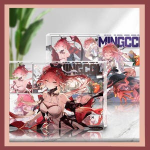 Puede incluir: Expositor acrílico transparente con una vibrante ilustración de estilo anime de un personaje con cabello rojo y un atuendo blanco y negro. El expositor tiene el texto "MINGCC" y otras imágenes del personaje. El tema general es merchandising de anime.