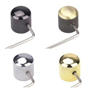 Op de afbeelding: Vier metalen gitaarknoppen in zwart, goud, zilver en messing. Elke knop heeft een getextureerd, gekarteld oppervlak en een glanzende, afgeronde bovenkant. Een zilveren inbussleutel is in elke knop gestoken.