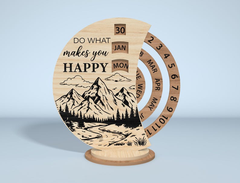 Puede incluir: Un calendario perpetuo de madera con un dise&ntilde;o de monta&ntilde;a y r&iacute;o. El calendario muestra el texto "DO WHAT makes you HAPPY" e incluye anillos giratorios para el mes y el d&iacute;a. La fecha es el 30 de enero, lunes.
