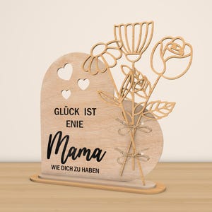 May include: Wooden sign with a heart shape and a bouquet of flowers. The sign reads "Gl&uuml;ck ist eine Mama wie dich zu haben" which translates to "Happiness is having a mom like you".