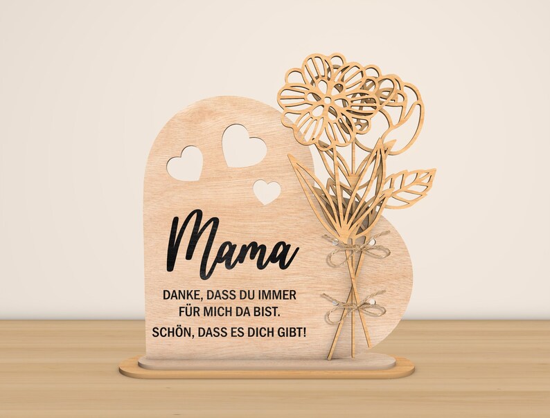May include: Wooden heart-shaped sign with a floral design and the text "Mama" and "Danke, dass du immer f&uuml;r mich da bist. Sch&ouml;n, dass es dich gibt!"