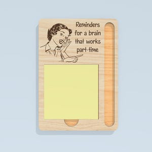 May include: A wooden memo board with a retro illustration of a woman whispering. The board has a slot for a notepad and a humorous quote: "Reminders for a brain that works part-time."