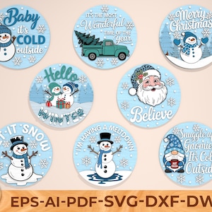 May include: A selection of circular, pale blue winter decorations. Each features a snowman, Santa, or gnome with winter-themed text such as "Baby it's cold outside" and "Merry Christmas." The decorations are designed for cutting files.