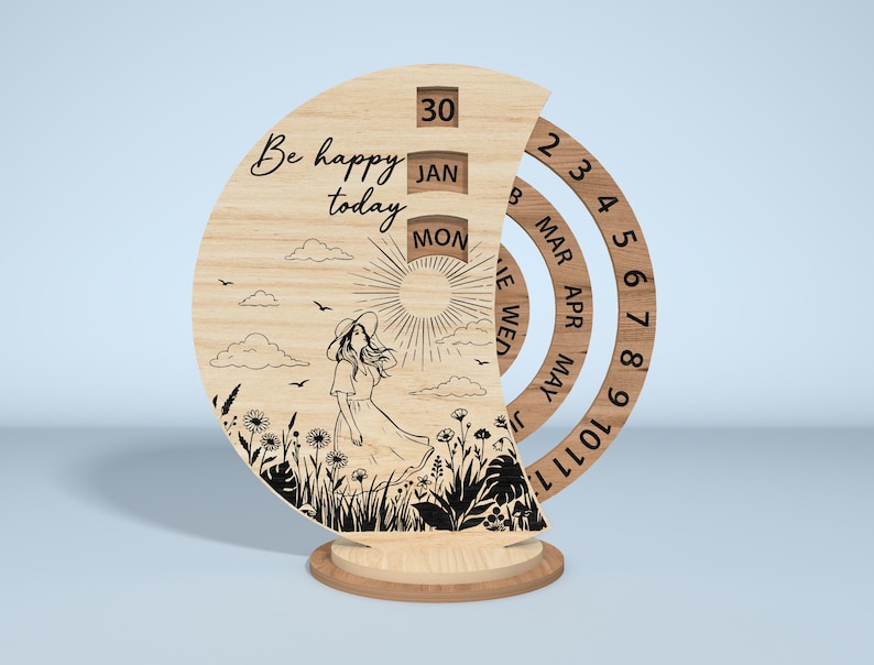 Puede incluir: Calendario perpetuo de madera con un dise&ntilde;o semicircular. El calendario presenta una ilustraci&oacute;n grabada con l&aacute;ser de una mujer en un campo, el texto "Be happy today" y anillos de fecha giratorios. La fecha muestra 30, JAN y MON.
