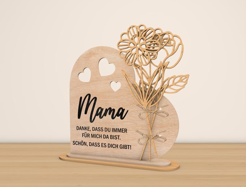 May include: Wooden heart-shaped sign with a cutout of flowers and the word "Mama" in black lettering. The sign also includes the text "Danke, dass du immer fur mich da bist. Schon, dass es dich gibt!"