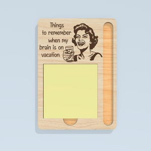 May include: Wooden memo board with a retro illustration of a woman holding a drink, and the text "Things to remember when my brain is on vacation." Includes a yellow sticky note pad and a pen holder.