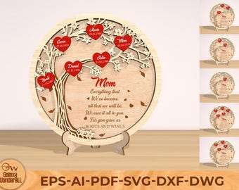 Puede incluir: Una placa redonda de madera con un diseño de árbol tallado y corazones rojos con nombres y fechas. El texto dice "Mamá Todo lo que hemos llegado a ser, todo lo que seremos. Te lo debemos todo. Porque nos diste RAÍCES Y ALAS".