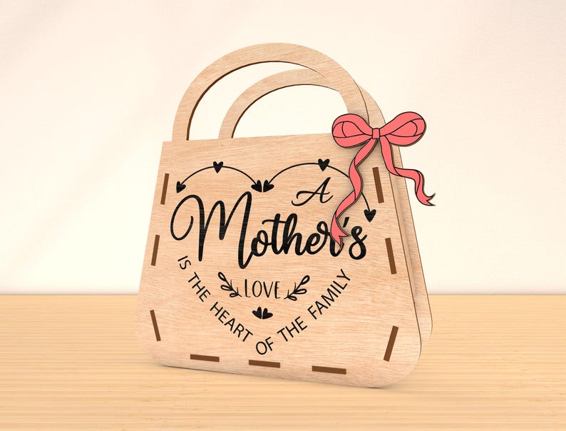 May include: A wooden gift bag with a pink bow and the text "A Mother's Love is the Heart of the Family".