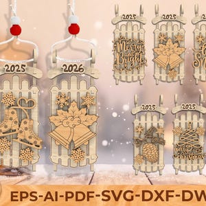 Puede incluir: Adornos navideños de madera con forma de trineos, cada uno con un diseño diferente. Algunos presentan patines de hielo, campanas, copos de nieve y textos como "Merry and Bright" y "Let it Snow". Cada adorno tiene una cuerda blanca con un pompón rojo.