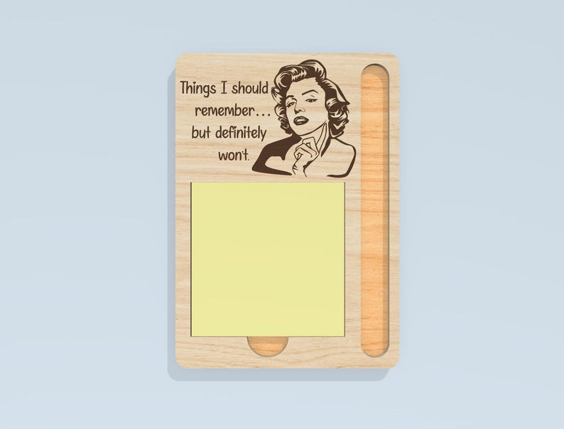May include: Wooden memo pad with a portrait of a woman and the text "Things I should remember... but definitely won't." The pad has a slot for a pen and a yellow sticky note pad.