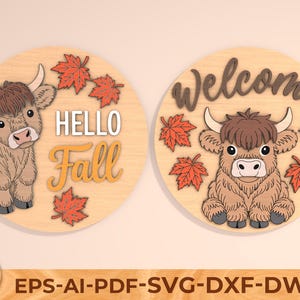 May include: Two round wooden signs featuring a Highland cow design. One sign reads "Hello Fall", the other "Welcome". Both signs have orange maple leaves. The signs are light brown with a light brown cow.