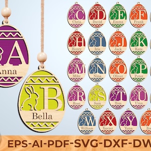 May include: Wooden Easter egg ornaments with a bunny and a letter, personalized with names. The eggs are in various colors, including purple, green, and orange. Each ornament has a string for hanging. The image also shows the letters A through Z.