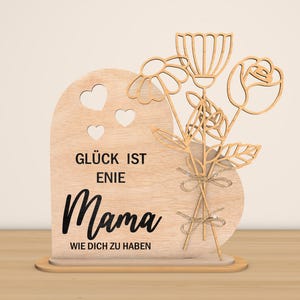 May include: Wooden sign with a heart shape and a bouquet of flowers. The sign reads "Gl&uuml;ck ist eine Mama wie dich zu haben" which translates to "Happiness is having a mom like you".