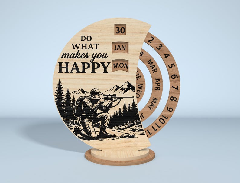 Puede incluir: Calendario perpetuo de madera con una ilustraci&oacute;n de cazador y el texto "Do what makes you HAPPY". El calendario presenta anillos giratorios para el mes y el d&iacute;a, con una base para sostenerlo. El cazador est&aacute; arrodillado y apuntando con un rifle.