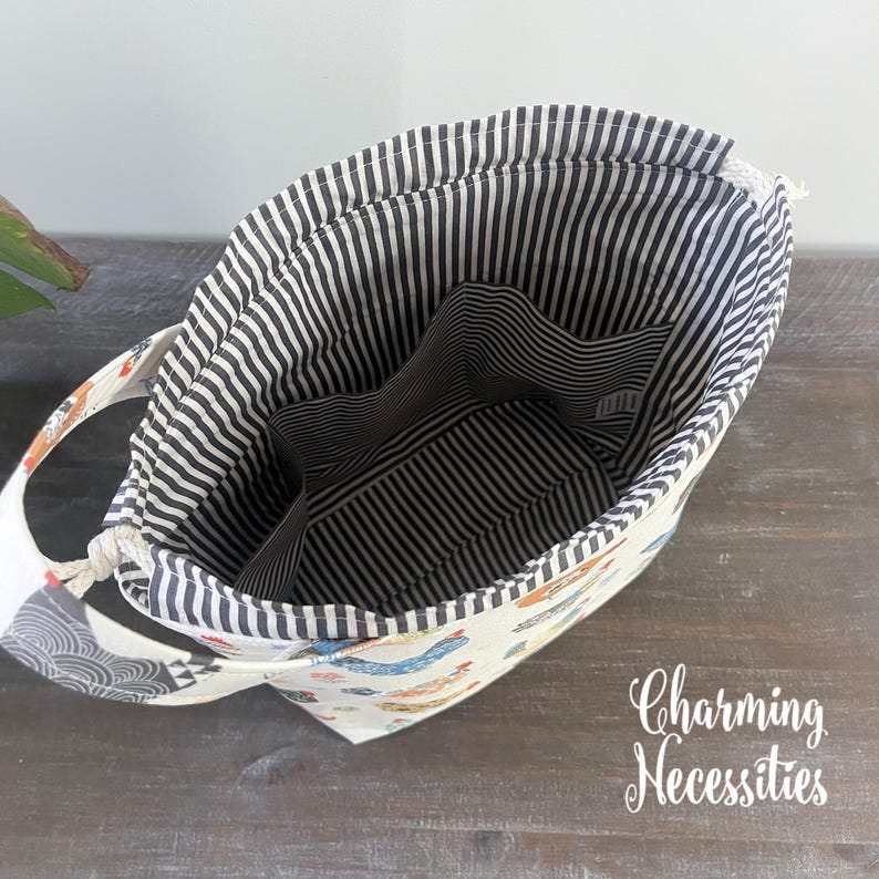 an open tote bag with a striped interior, resting on a wooden surface.